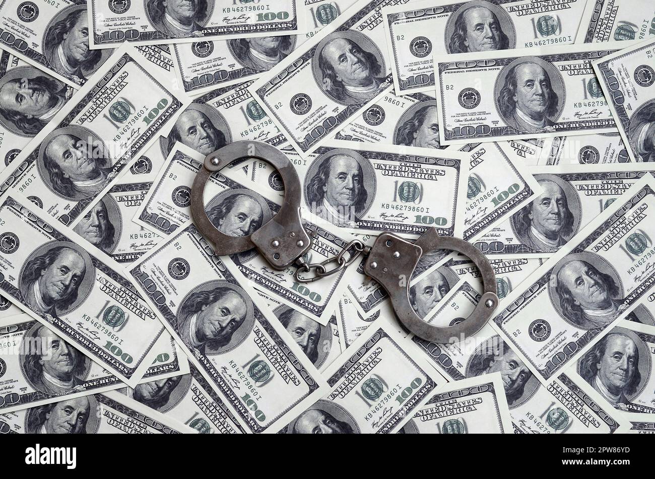 Polizei Handschellen liegen auf einer Menge Dollarscheine. Das Konzept der illegale Besitz von Geld, illegale Geschäfte mit US-Dollar. Wirtschaftskriminalität Stockfoto