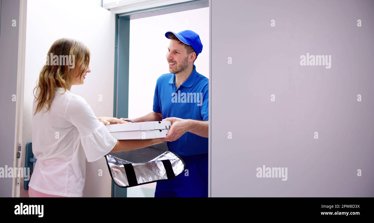 Pizzamann Pizza-Kartons zu lächelnde junge Frau geben Stockfoto