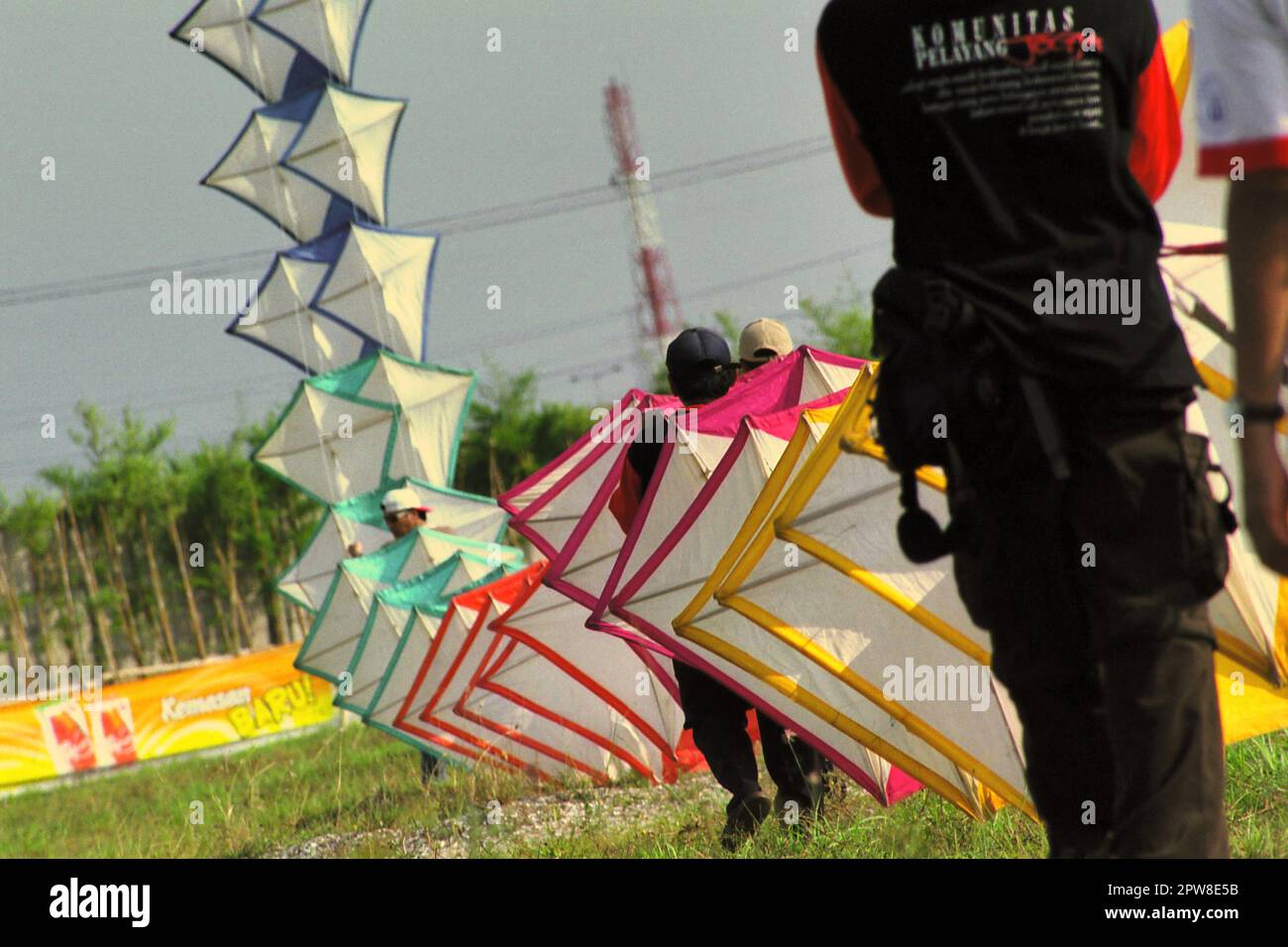 Männer, die während des 2004 Jakarta International Kite Festivals, das am 9-11. Juli am Karnaval (Karneval) Beach in Ancol Dreamland, North Jakarta, Jakarta, Indonesien, stattfand, einen riesigen Drachen fliegen. Stockfoto