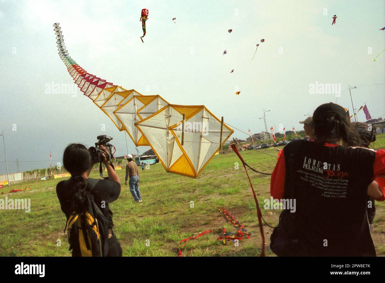 Männer, die während des 2004 Jakarta International Kite Festivals, das am 9-11. Juli am Karnaval (Karneval) Beach in Ancol Dreamland, North Jakarta, Jakarta, Indonesien, stattfand, einen riesigen Drachen fliegen. Stockfoto