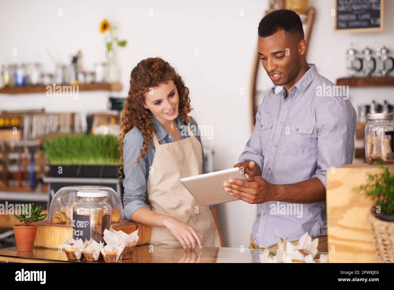 Tablet, Café-Besitzer und Teamwork von Personen, die sich unterhalten, Bestellungen besprechen und verwalten. Kellner, schwarzer Mann und Frau im Restaurant mit Technologie für Stockfoto