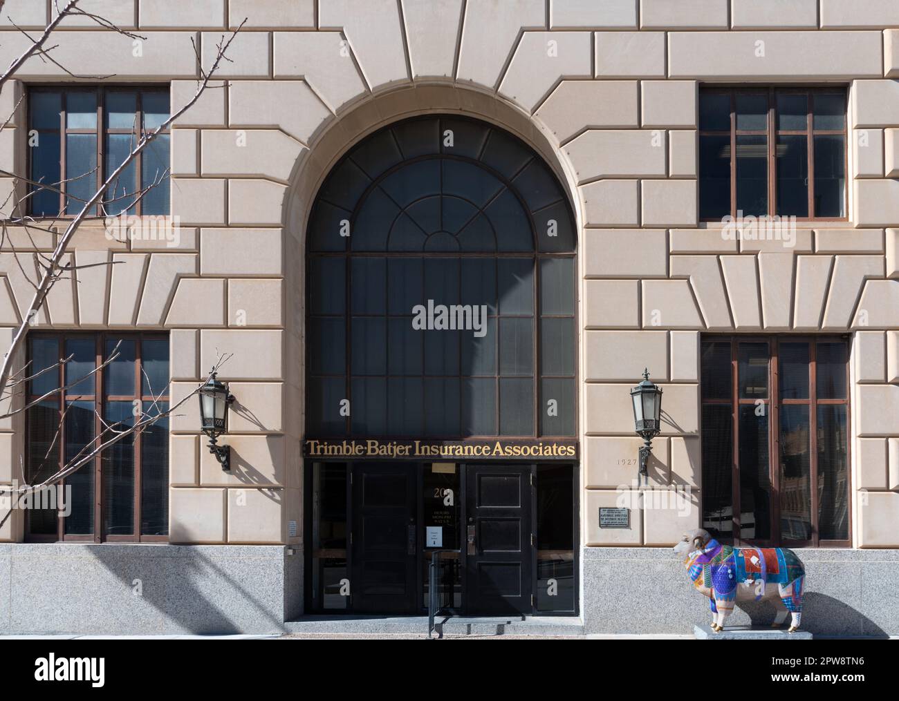 Rustikale Kalksteinfassade des ehemaligen San Angelo National Bank Building, San Angelo, TX. Auf dem Schild steht Trimble Batjer Insurance Associates Stockfoto