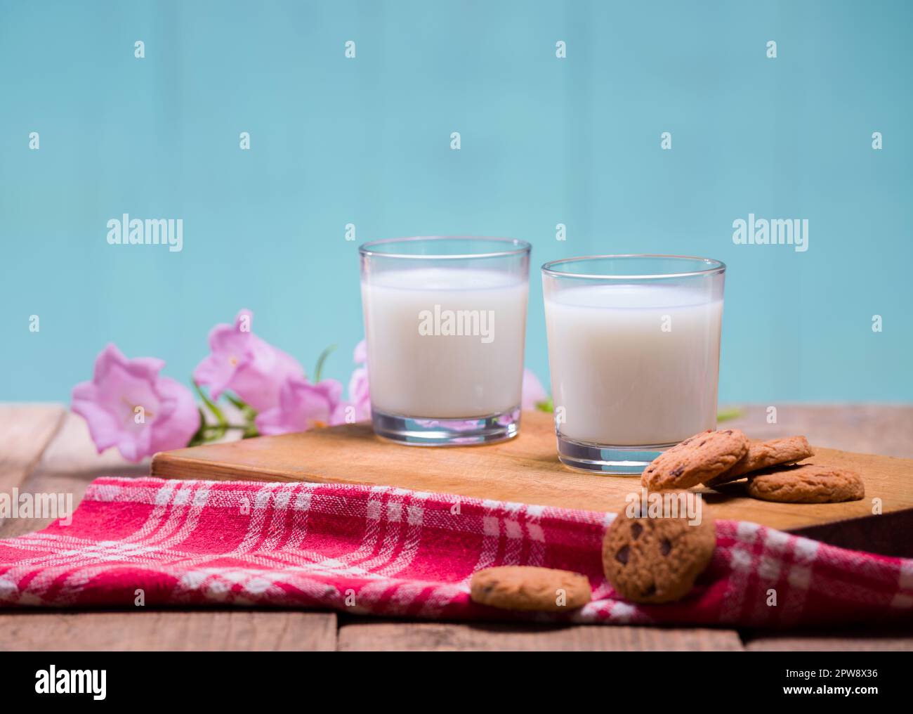 Milchgläser und Kekse auf Holztisch. Stockfoto
