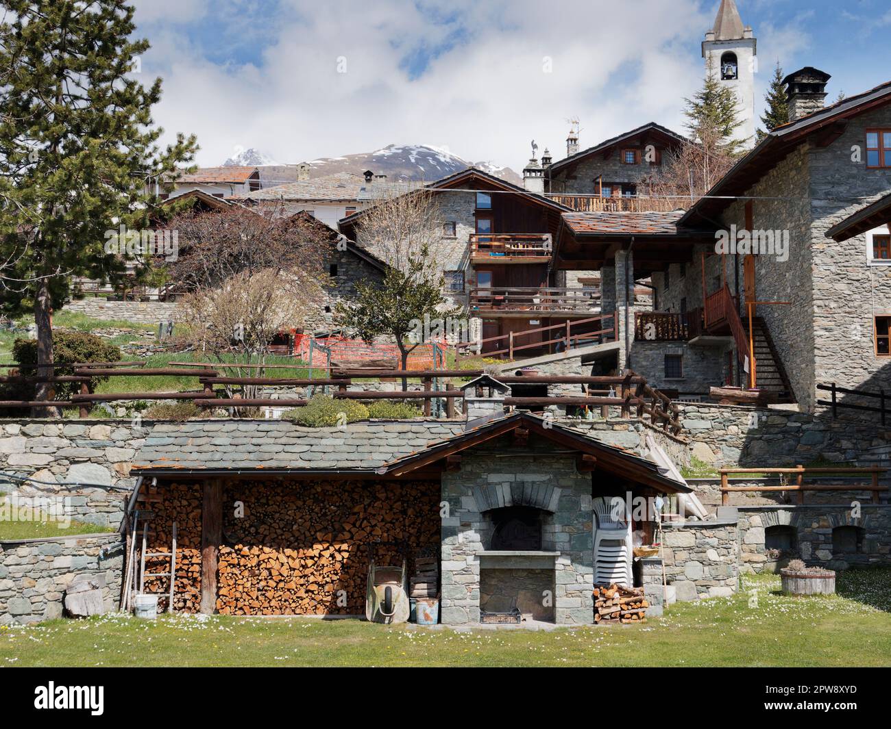 Traditionelle und malerische Steinhäuser mit einem Holzstapel im Vordergrund in der Alpenstadt Lignan im Aosta Vally, nordwestlich von Italien Stockfoto