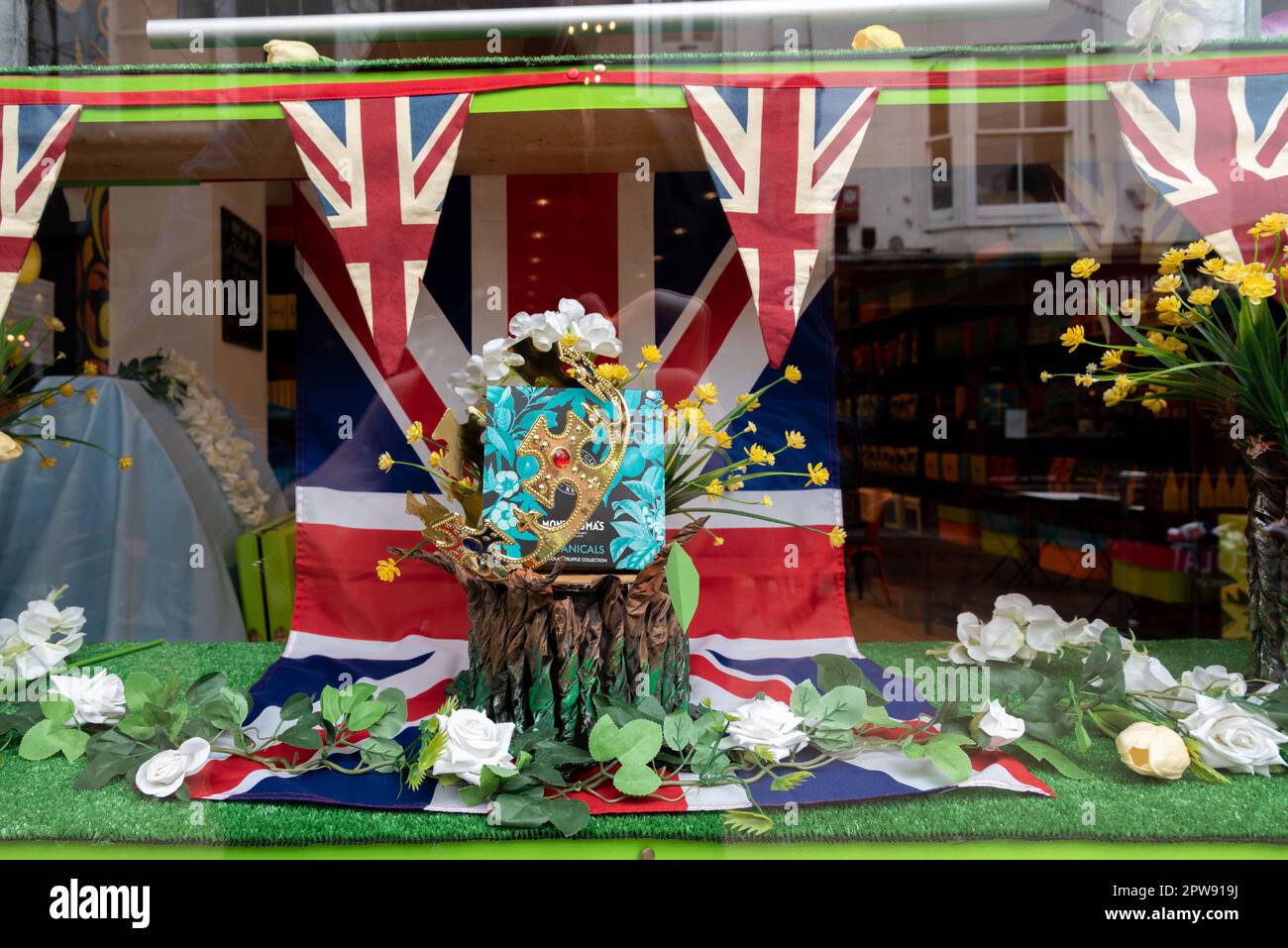 Patriotische Schaufensterausstellung mit Union Jack-Fahnenzug und Fahne sowie eine goldene Krone für die Krönung von König Karl 3. Stockfoto