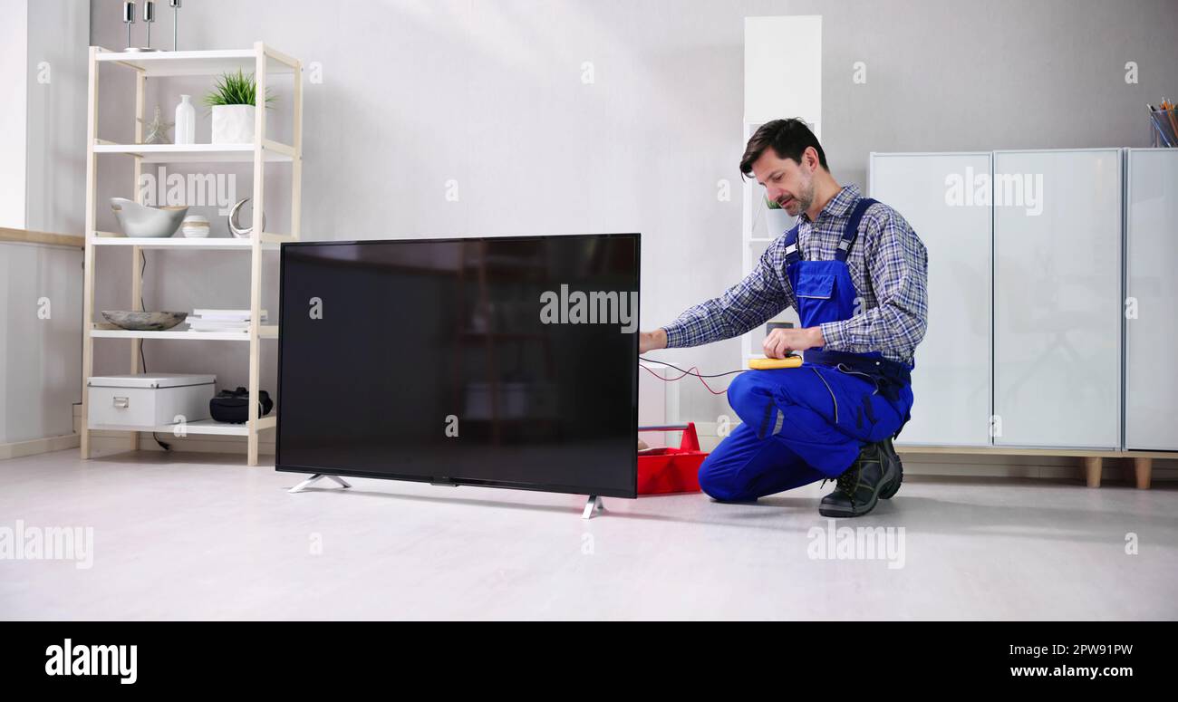 Junge männliche Elektriker im Allgemeinen Kontrolle Fernsehen Stockfoto