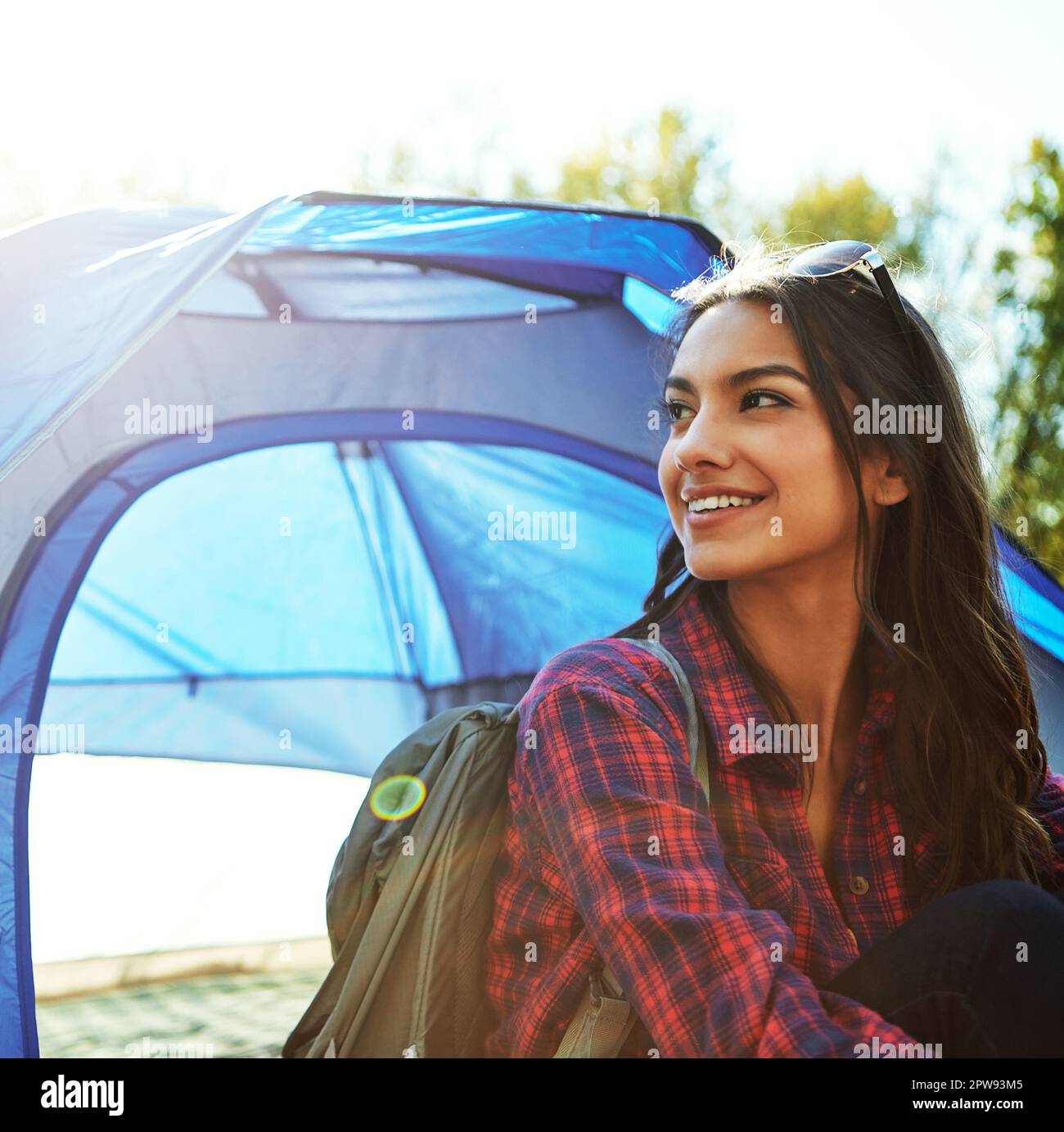 Sie entkommt allem. Eine attraktive junge Frau, die auf ihrem Campingplatz sitzt. Stockfoto