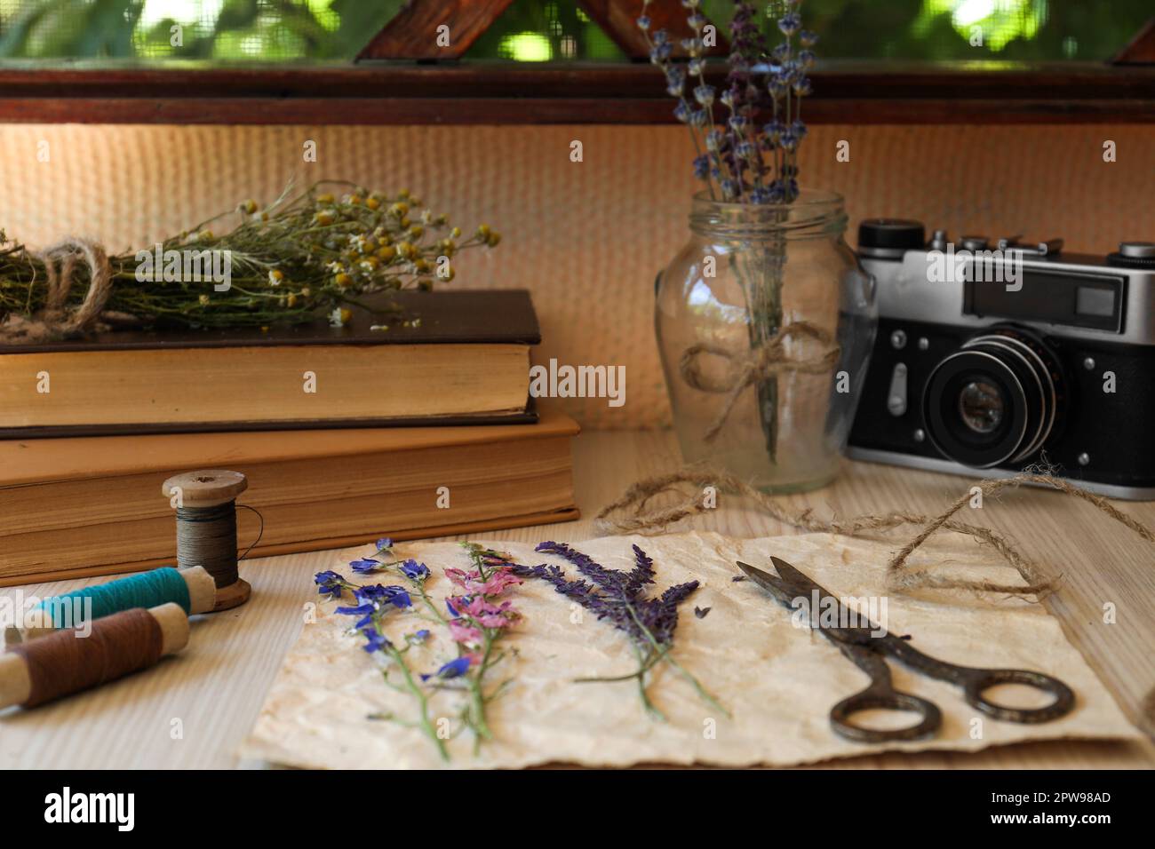 Komposition mit schönen getrockneten Blumen und Papier auf Holztisch Stockfoto