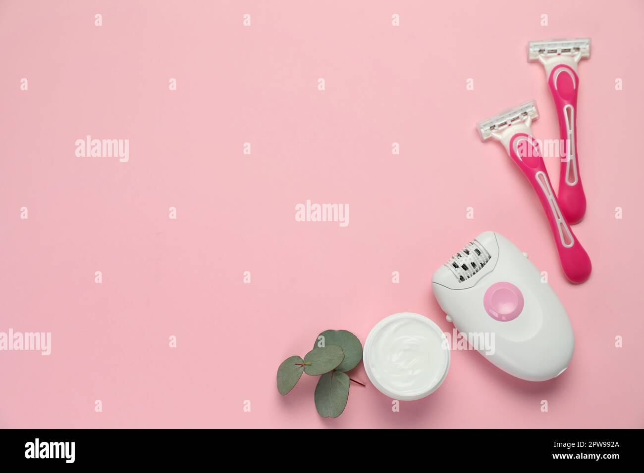 Moderner Epilierer, Rasierer, Creme und Eukalyptuszweig auf pinkfarbenem Hintergrund, flach liegend. Platz für Text Stockfoto