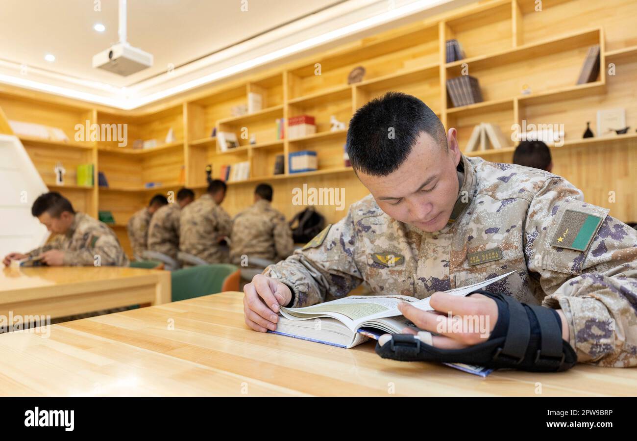 (230429) -- KHUNJERAB, 29. April 2023 (Xinhua) -- Soldaten lesen Bücher in einem Leseraum in der Baracke in Khunjerab, Nordwestchina, Uygur Autonomer Region Xinjiang, 13. April 2023. Gao Guanghui, ein Rekrut, der erst seit 7 Monaten der Armee beigetreten war, war schockiert, als er den Ehrenraum des Grenzverteidigungsregiments in Khunjerab im Nordwesten Chinas Uygur Autonomer Region Xinjiang betrat. Das Regiment basiert auf den Pamiren und bewacht die China-pakistanische Grenze und den Hafen von Khunjerab. Mit einer durchschnittlichen Höhe von 4.700 Metern ist der Ort eine „verbotene Zone“ für viele Menschen, wie die Temperatur Stockfoto