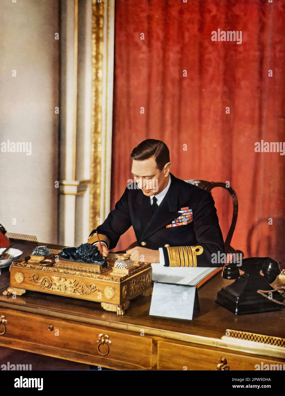 König George V1 von Großbritannien, 1942 fotografiert, arbeitete an seinem Schreibtisch in einem speziell in Auftrag gegebenen Farbfoto, um das hundertjährige Bestehen der illustrierten London News zu feiern. Stockfoto