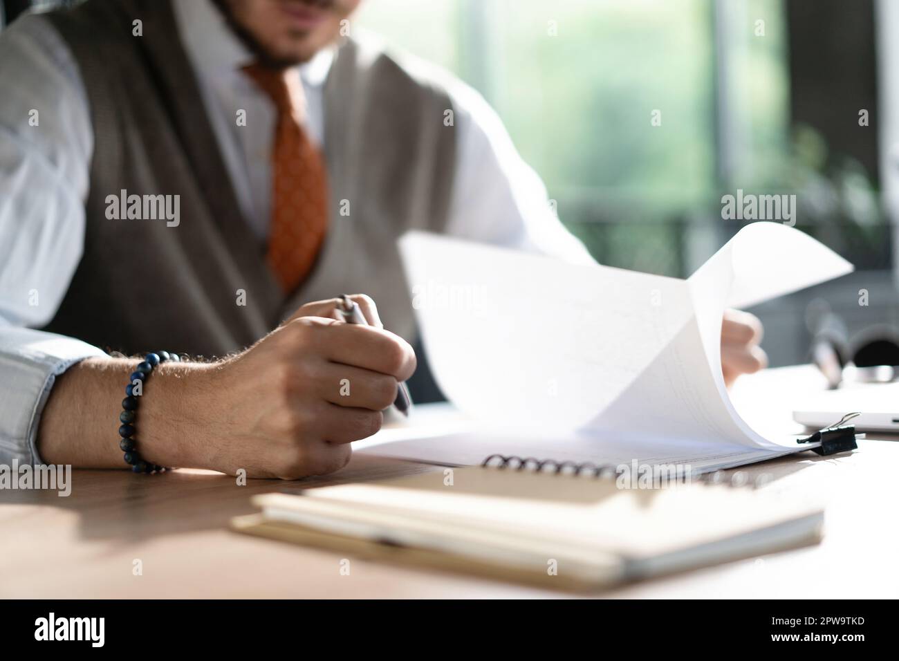 Geschäftsleute halten einen Stift, um mit einem Stapel Papierakten zu arbeiten, Informationen zu durchsuchen, Geschäftsberichte und Stapel unfertiger Dokumente i Stockfoto