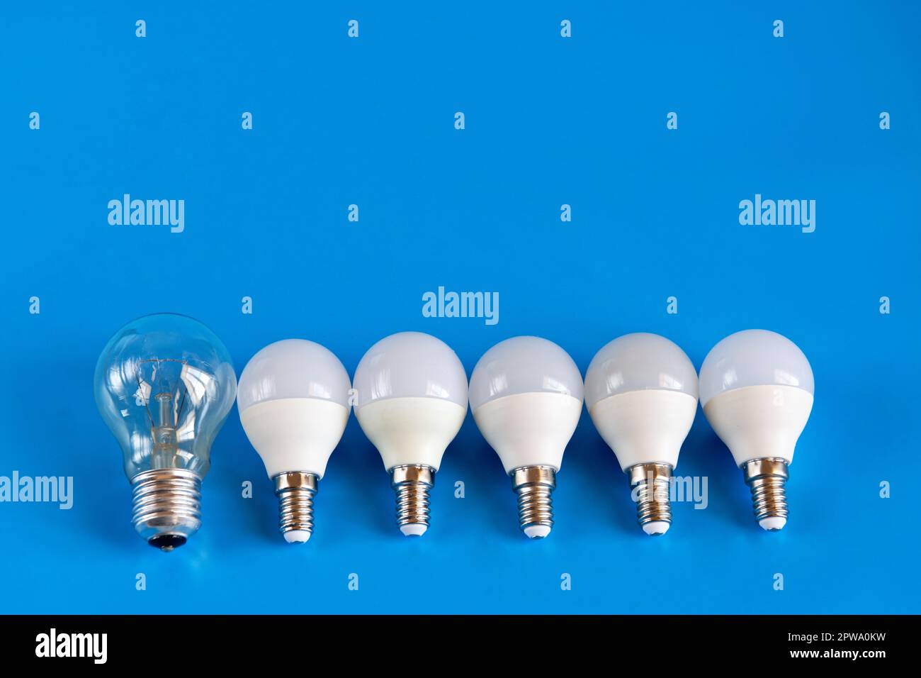 Energiesparende LED-Lampen mit Glühlampe in einer Reihe auf blauem Hintergrund. Das Konzept der Energieeinsparung. Schließen. Stockfoto
