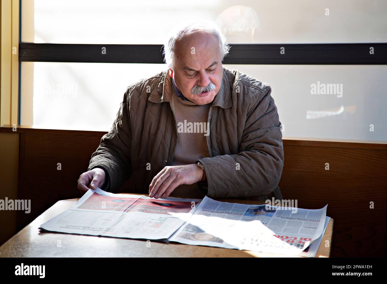 Alter Mann liest Zeitung im Café, Castellina in Chianti, Toskana, Italien Stockfoto