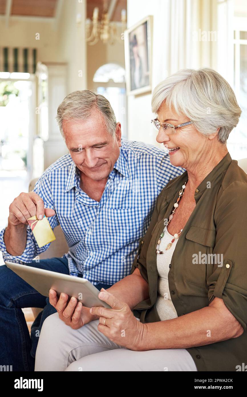 Alles, was Sie benötigen, ist online verfügbar. Ein älteres Paar kauft online auf seinem Tablet ein. Stockfoto