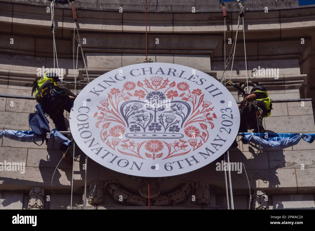 London, Großbritannien. 29. April 2023 Vor der Krönung von König Karl III., die am 6. Mai stattfindet, installieren die Arbeiter am Admiralty Arch in der Mall ein riesiges Krönungszeichen. Kredit: Vuk Valcic/Alamy Live News Stockfoto