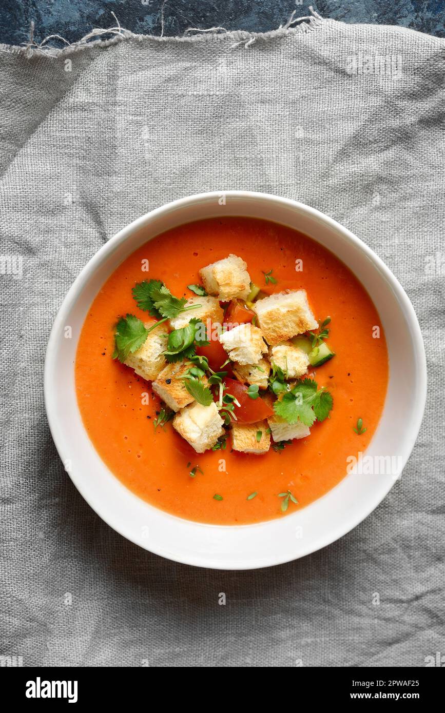 Tomaten-Gazpacho-Suppe mit Croutons in der Schüssel. Gesundes Lebensmittelkonzept. Draufsicht, flach liegend Stockfoto