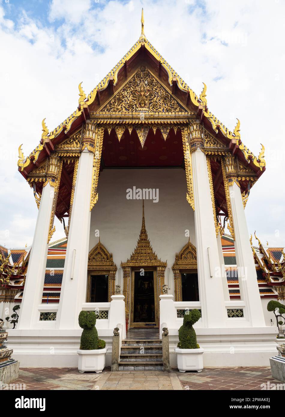 Dieses Foto zeigt ein kleines Tempelgebäude mit aufwändigen goldenen Dachdetails im Wat Pho Komplex in Bangkok, Thailand. Der Komplex de Stockfoto