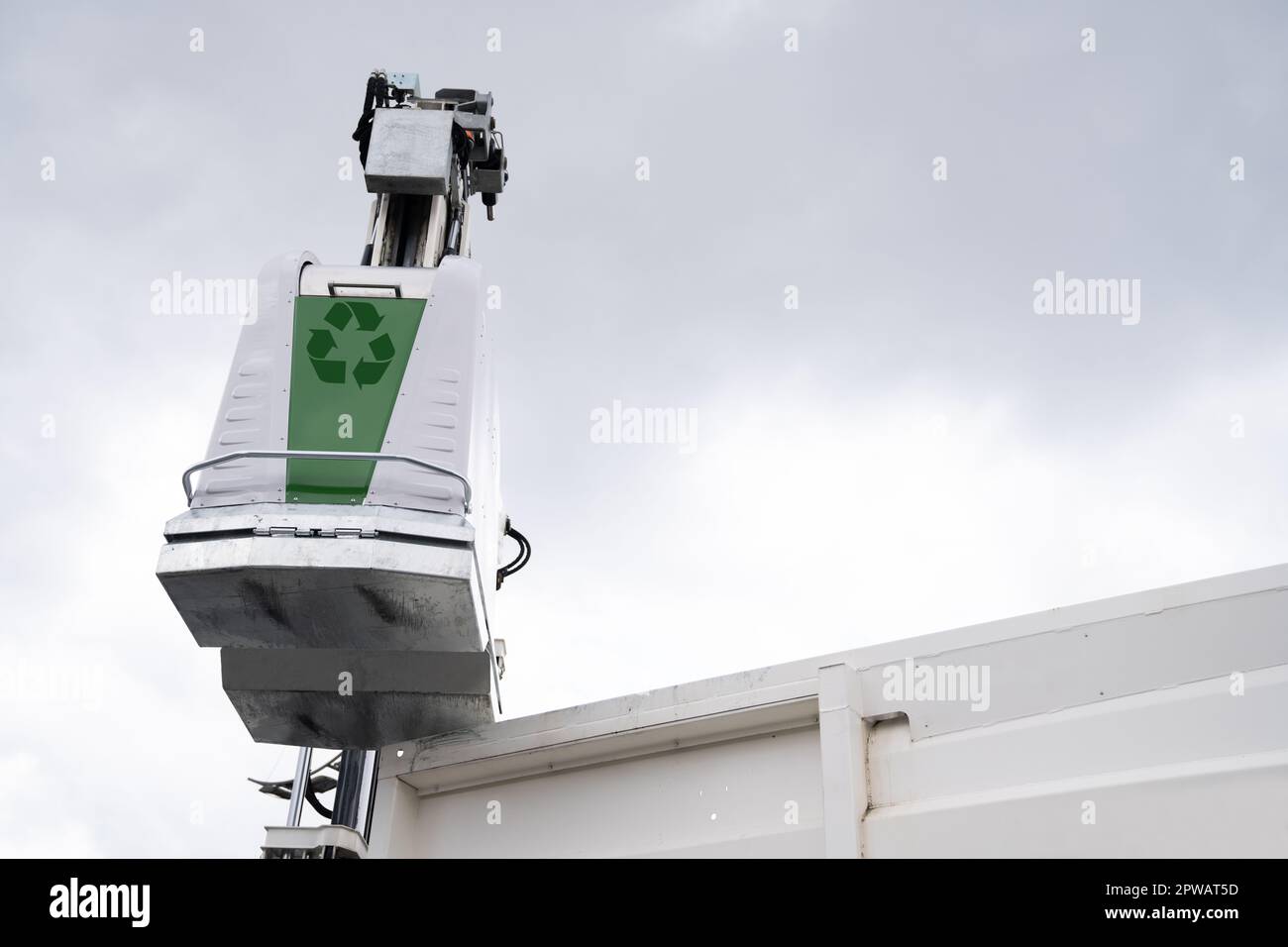 Müllwagen hebt Müllcontainer für recycelbaren Abfall an. Hochwertiges Foto Stockfoto