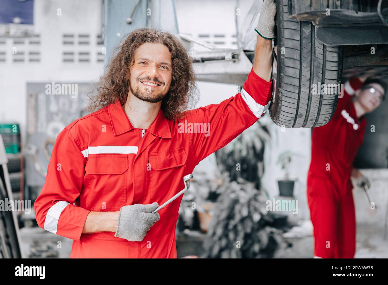 Porträt glückliche Mechaniker in der Garage genießen den Autoservice. Reifenwechsel in der Werkstatt für Garagenautos. Stockfoto