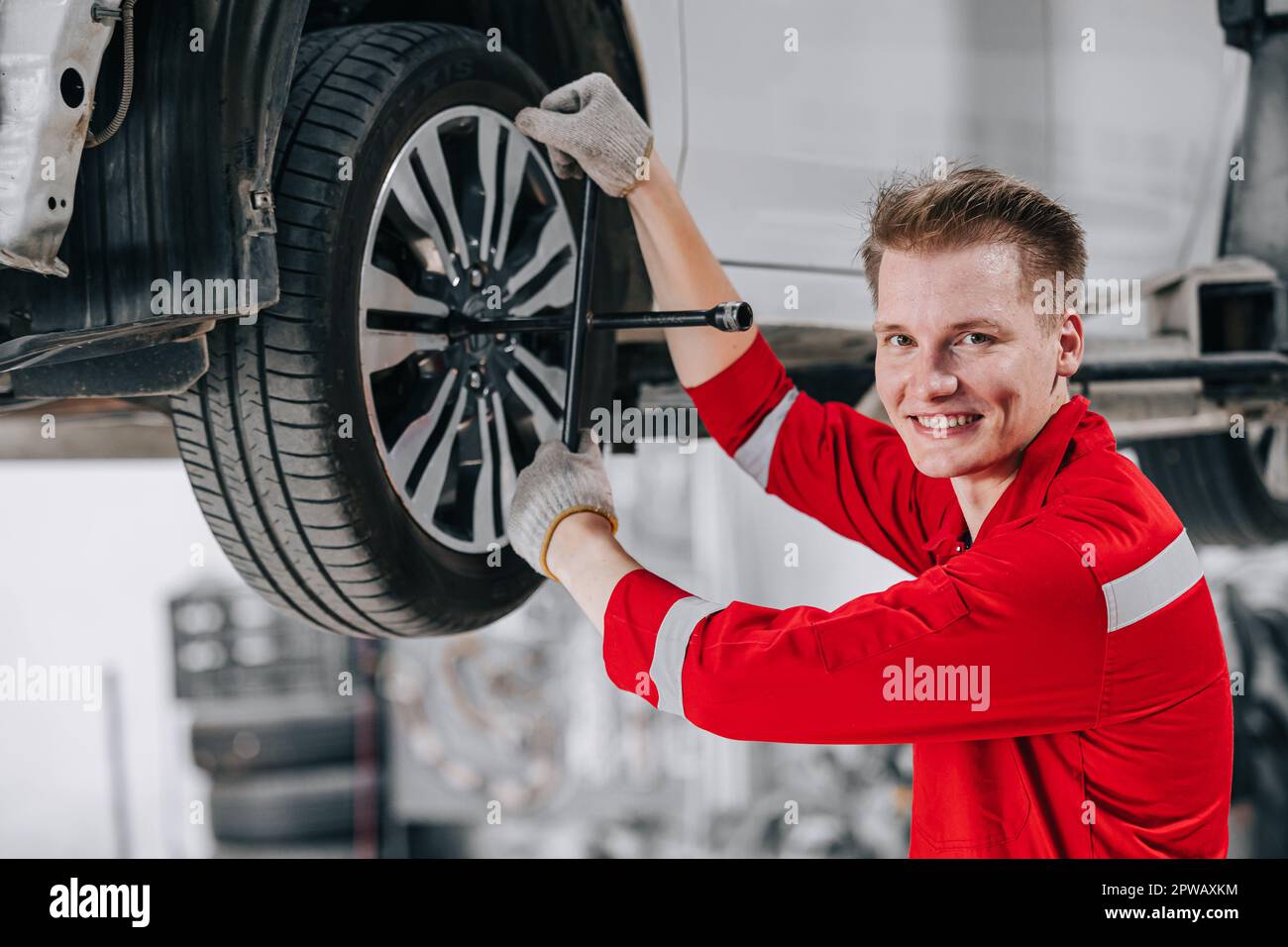 Porträt glückliche Mechaniker in der Garage genießen den Autoservice. Reifenwechsel in der Werkstatt für Garagenautos. Stockfoto
