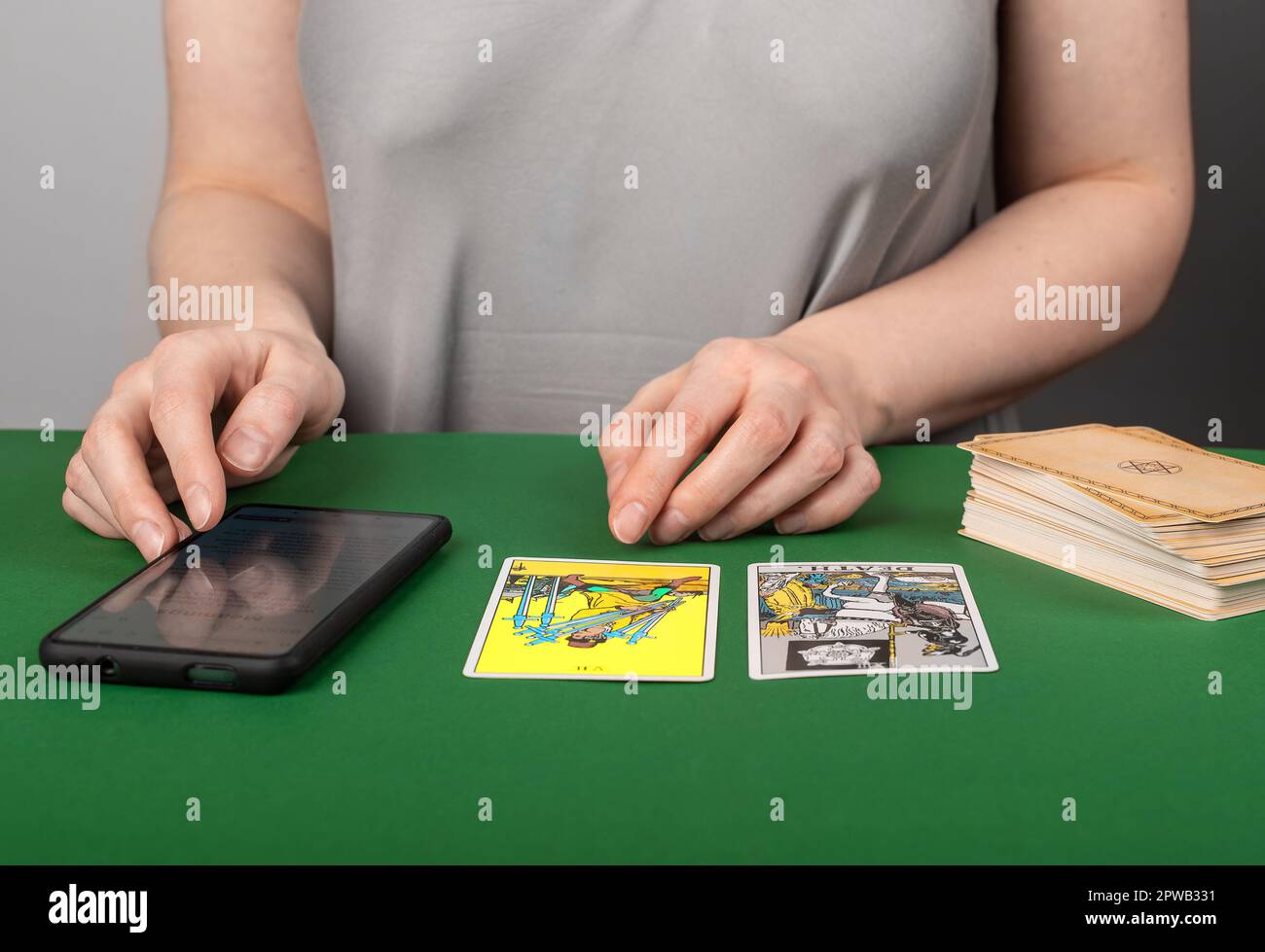 Tarot-Kartenlesen mit mobiler App, Telefon. Moderner Wahrsager mit Smartphone. Stockfoto