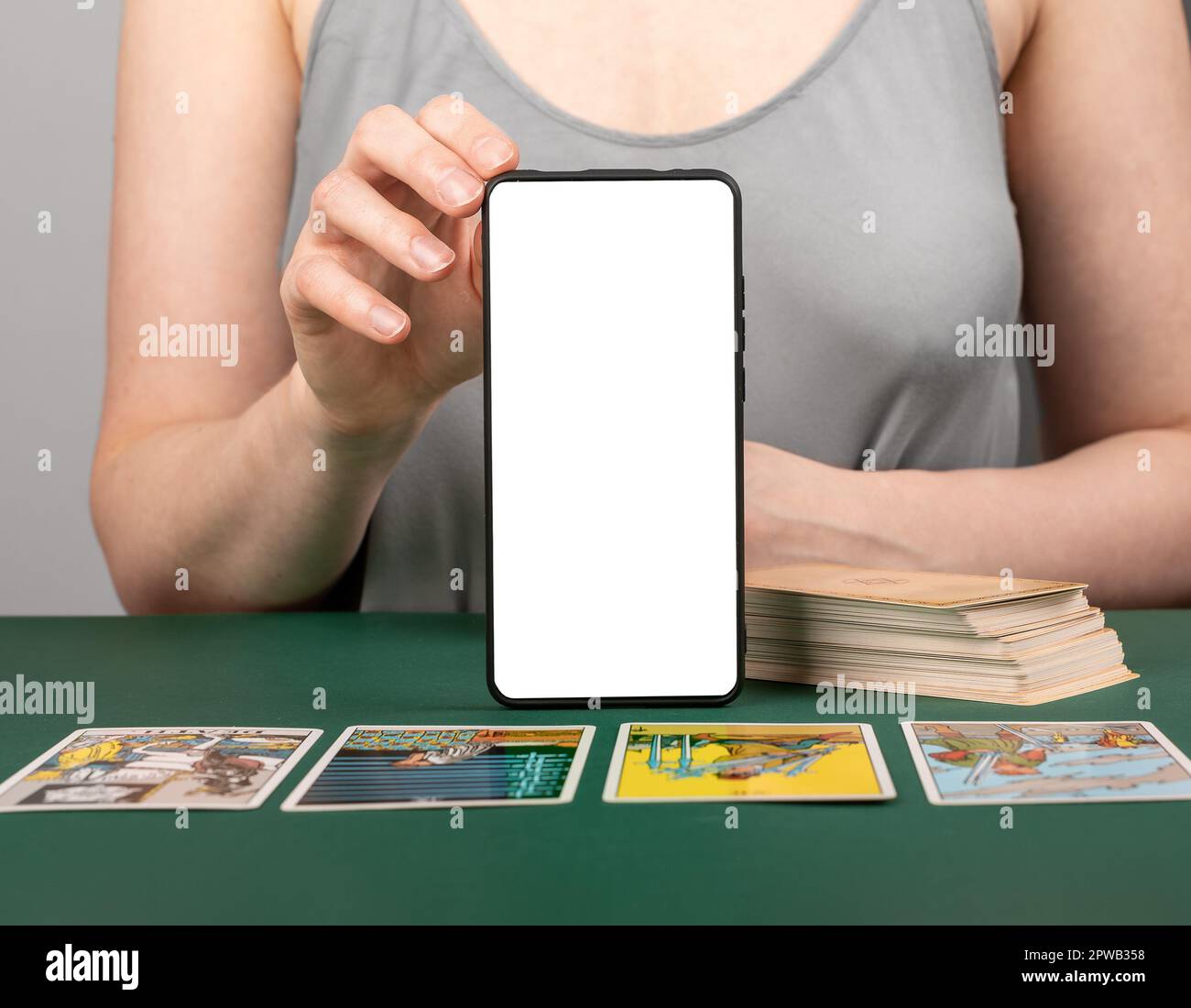 Tarot-Kartenlesen mit Bildschirmmodell des Mobiltelefons. Taro Reader mit moderner Anwendung auf Smartphone. Stockfoto