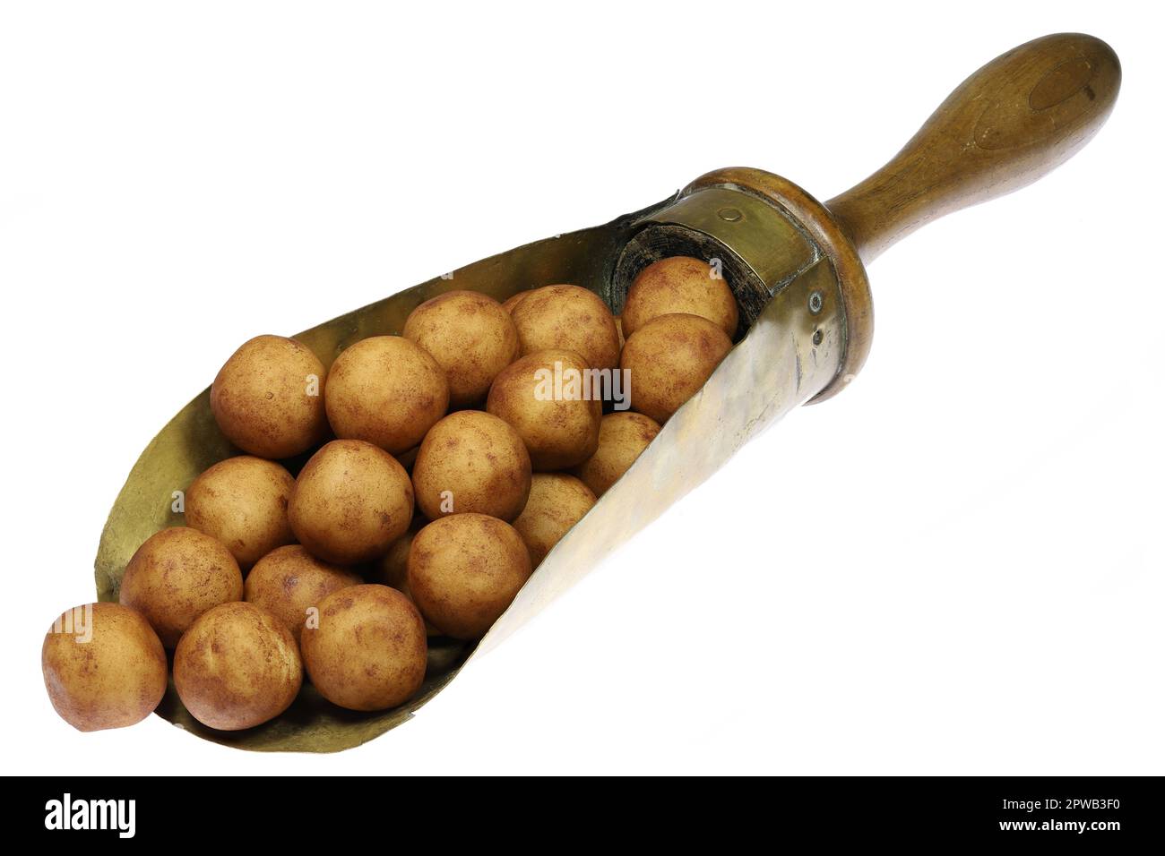 Marzipan-Kartoffeln aus Lubeck, Deutschland, in einer klassischen Messing-Wägeschaufel, isoliert auf weißem Hintergrund Stockfoto