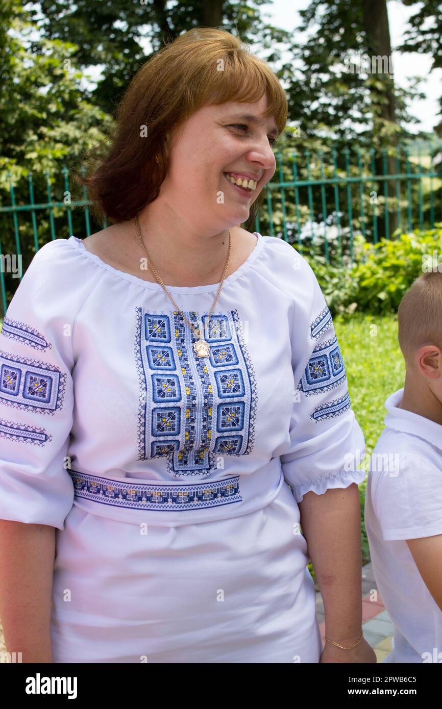 Glückliche Frau, die in einem in der Natur bestickten Kleid lacht Stockfoto