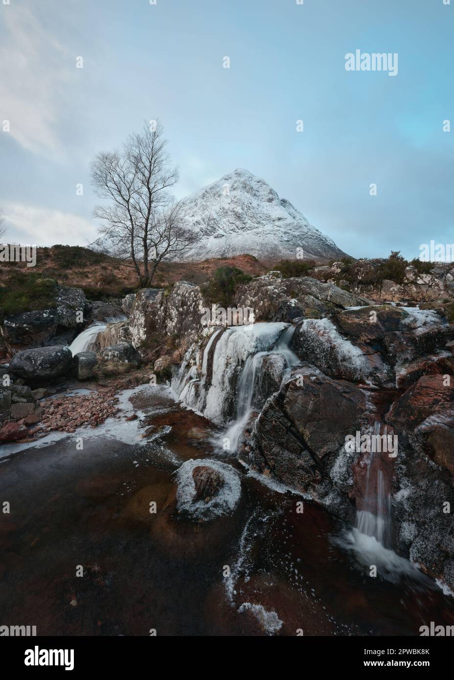 Bergfluss und teilweise gefrorener Wasserfall am Fuße des schneebedeckten Buachaille Etive Mor. Etive Mor Wasserfall. Am Eingang zum Tal von Glencoe in den schottischen Highlands, Schottland Stockfoto