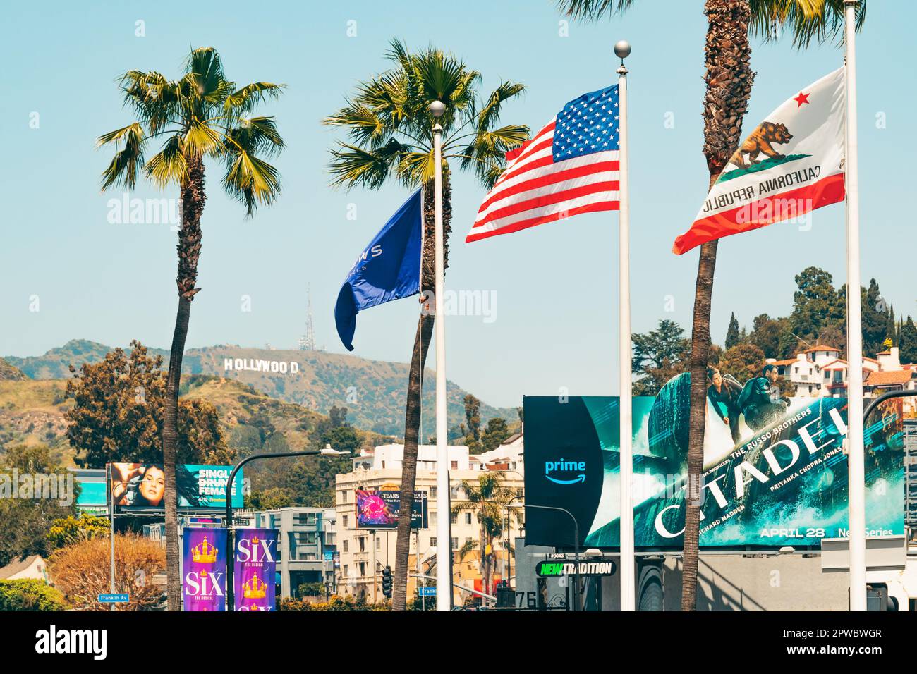 Los Angeles, Kalifornien, USA - 26. April 2023. Hollywood-Hügel und Hollywood-Schild, bunte Plakate, Palmen, Verkehr, Touristen Stockfoto