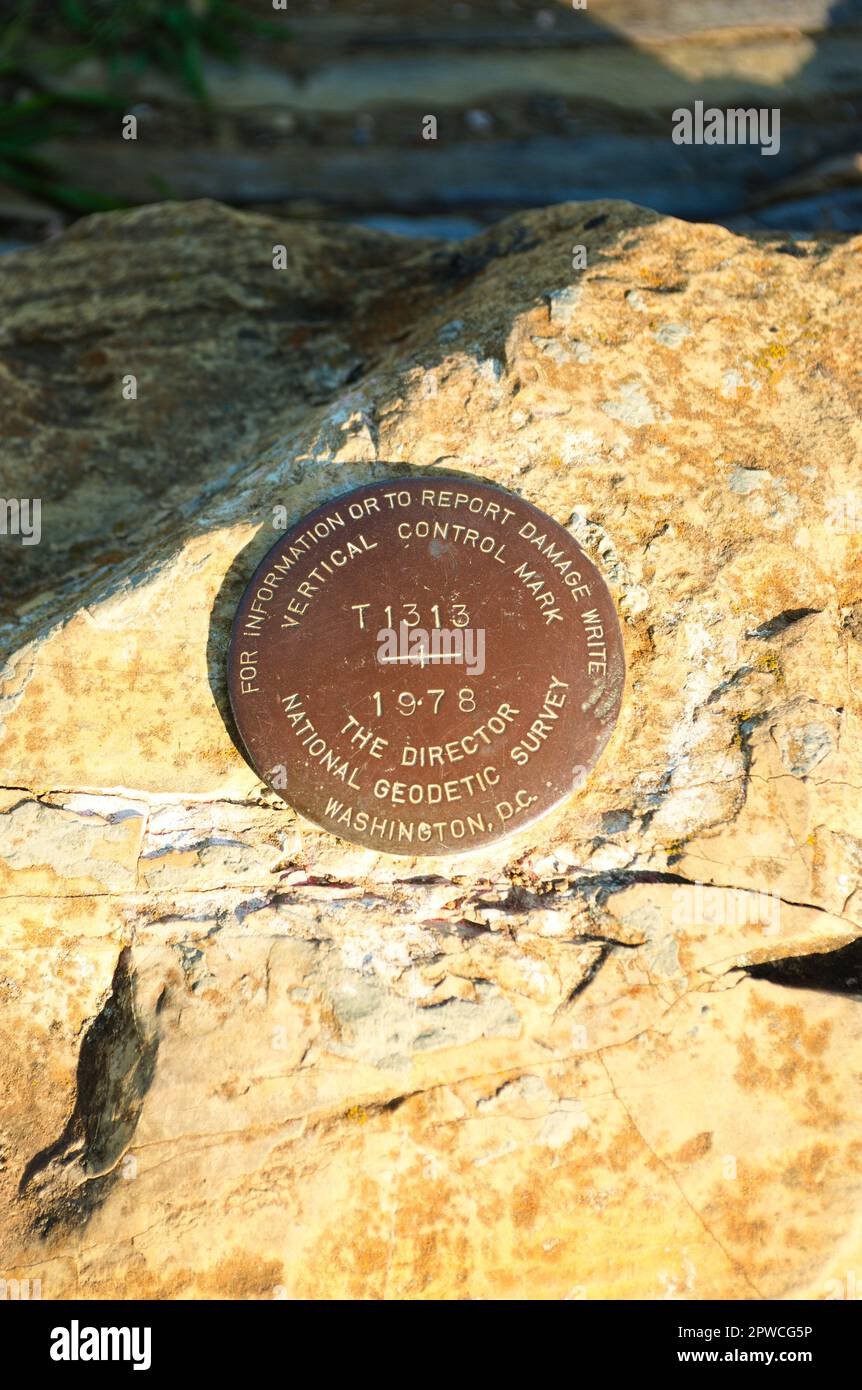 Vertical Control Marker, eine US American National Geodetic Survey, ist eingebettet in einen Felsen entlang einer malerischen kalifornischen Küste. Hochwertiges Foto Stockfoto
