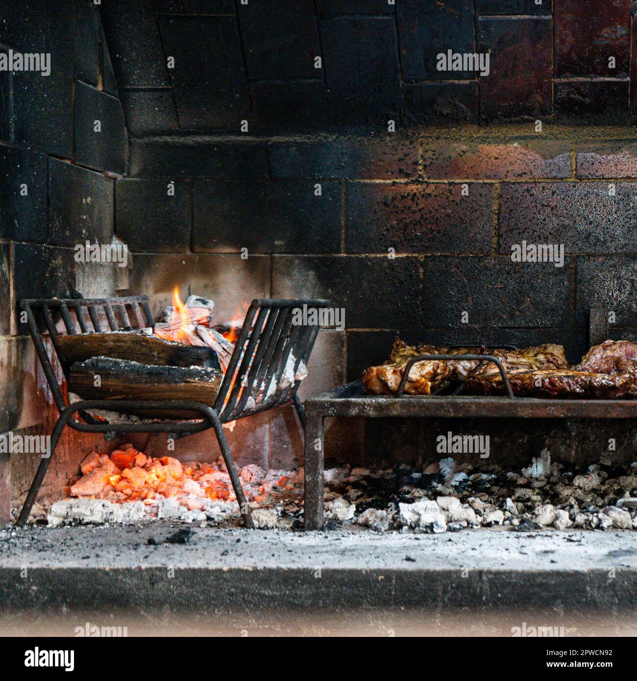 Flammen des Feuers und gebratenes Fleisch. Argentinisches Barbecue Stockfoto