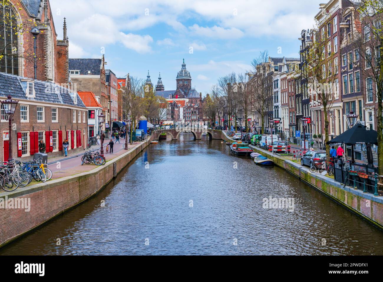 AMSTERDAM, HOLLAND - 18. APRIL 2023: Blick auf einen Kanal in Amsterdam, niederländische Hauptstadt, bekannt für sein aufwändiges Kanalsystem, enge Häuser und Radfahren Stockfoto