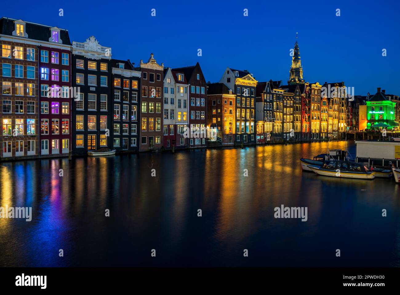 AMSTERDAM, HOLLAND - 18. APRIL 2023: Typische holländische Häuser säumen einen Kanal in der niederländischen Hauptstadt, bekannt für sein künstlerisches Erbe, ein ausgeklügeltes Kanalsystem Stockfoto