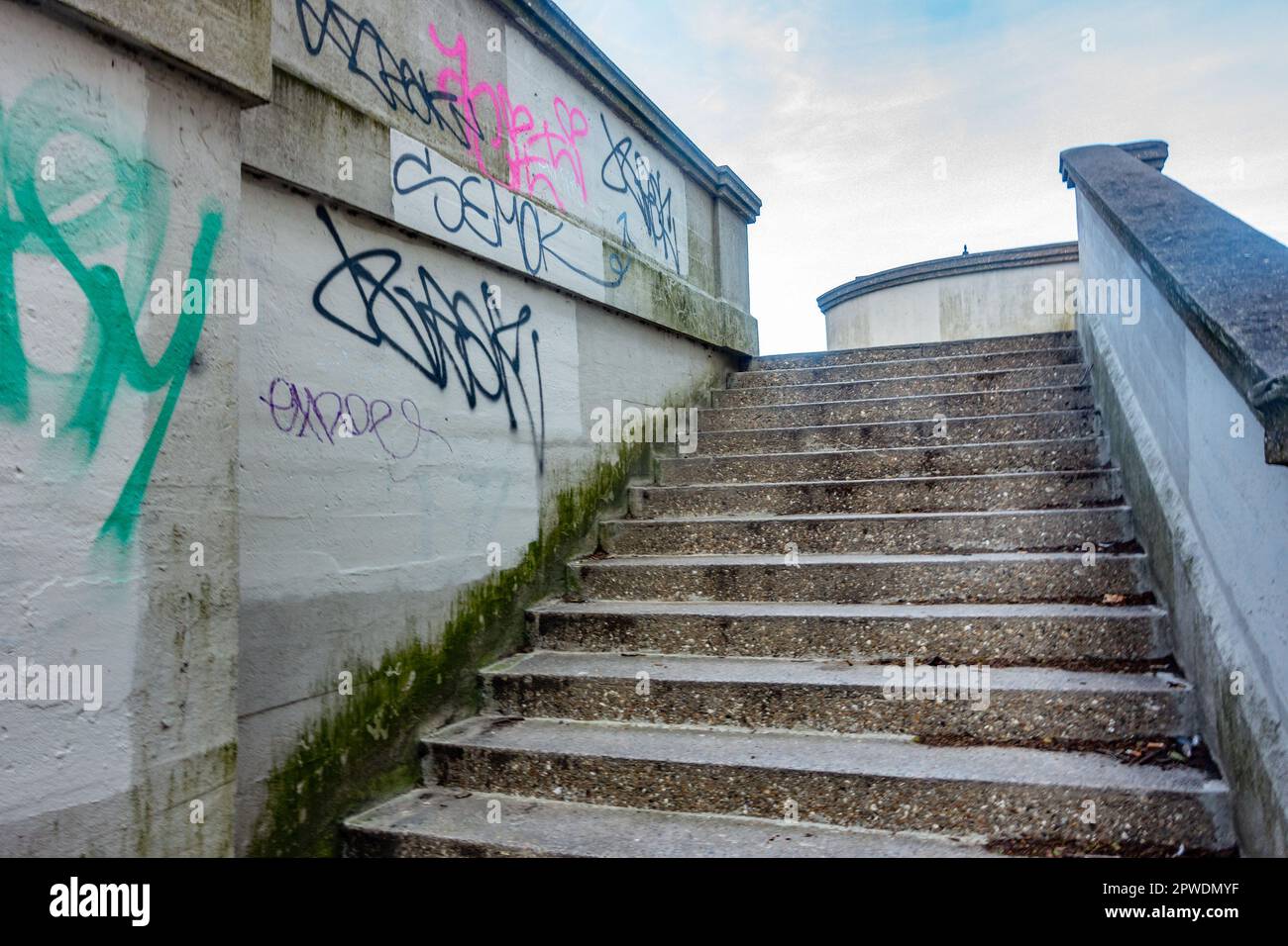 Betontreppen, die zur Lesebrücke führen. Die Wand ist mit Graffiti bedeckt. Stockfoto