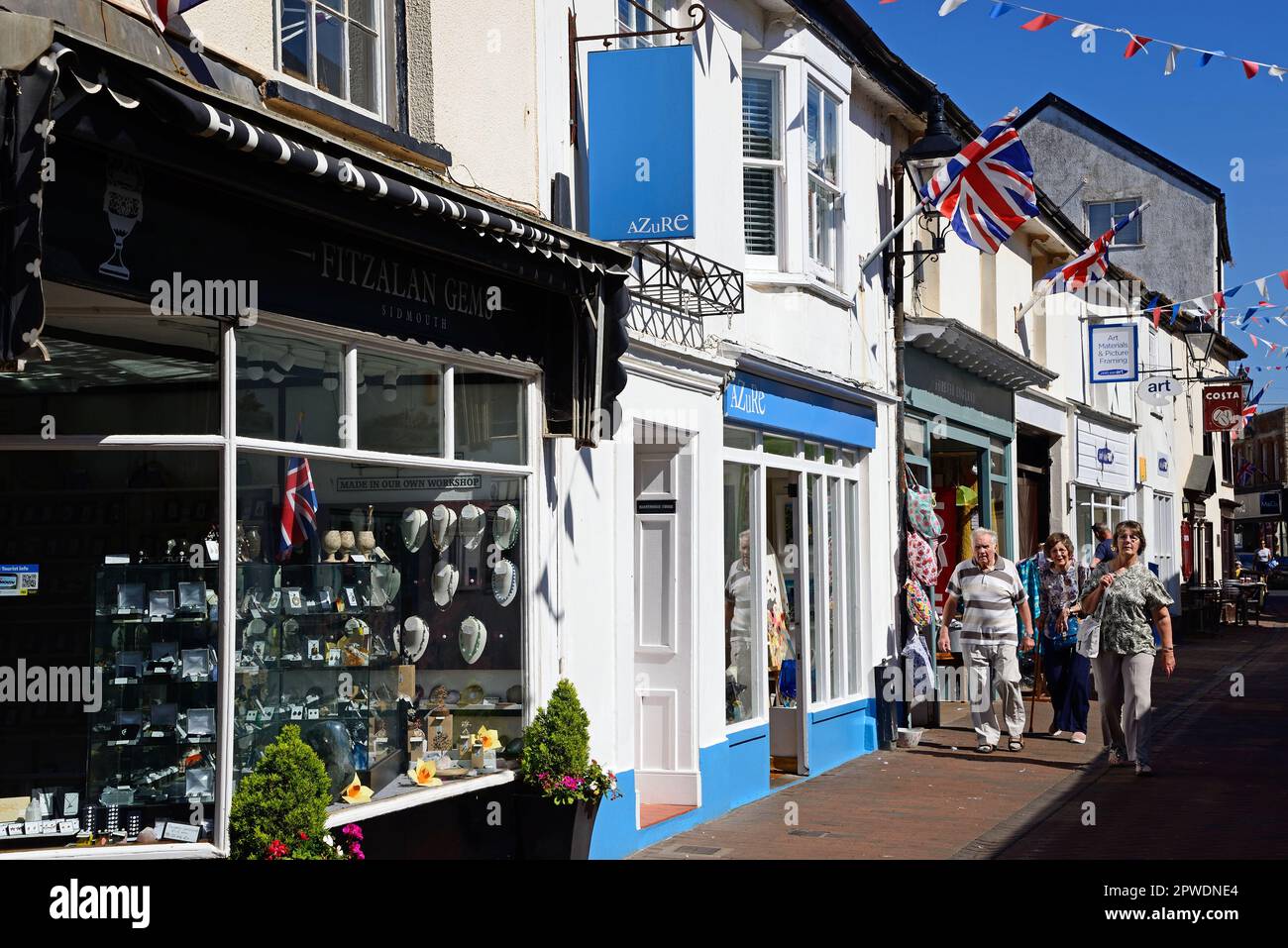 Shoppers und Shops entlang der Old Fore Street im Stadtzentrum, Sidmouth, Devon, Großbritannien, Europa. Stockfoto