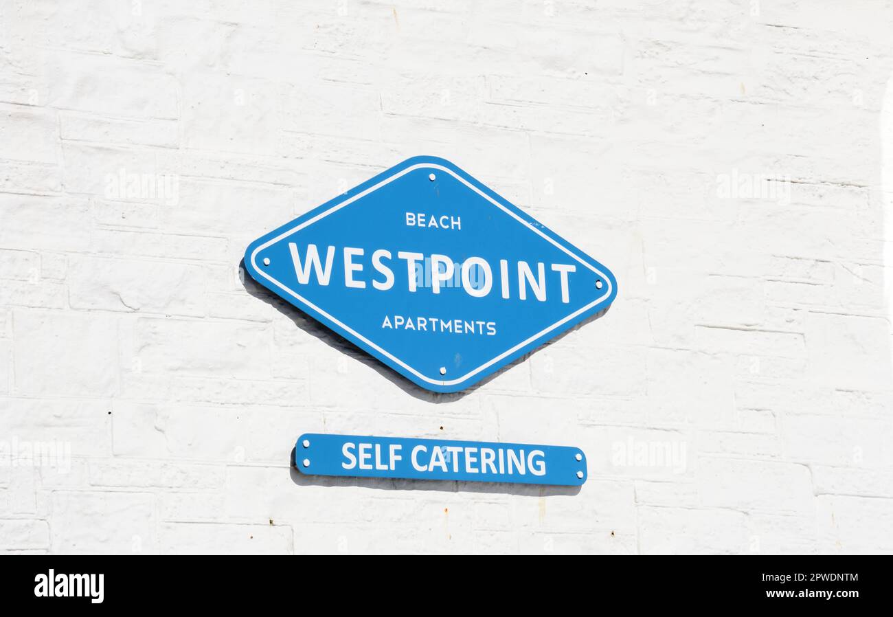 Westpoint Beach Apartments Schild vor einer weißen Mauer, West Bay, Dorset, Großbritannien, Europa. Stockfoto