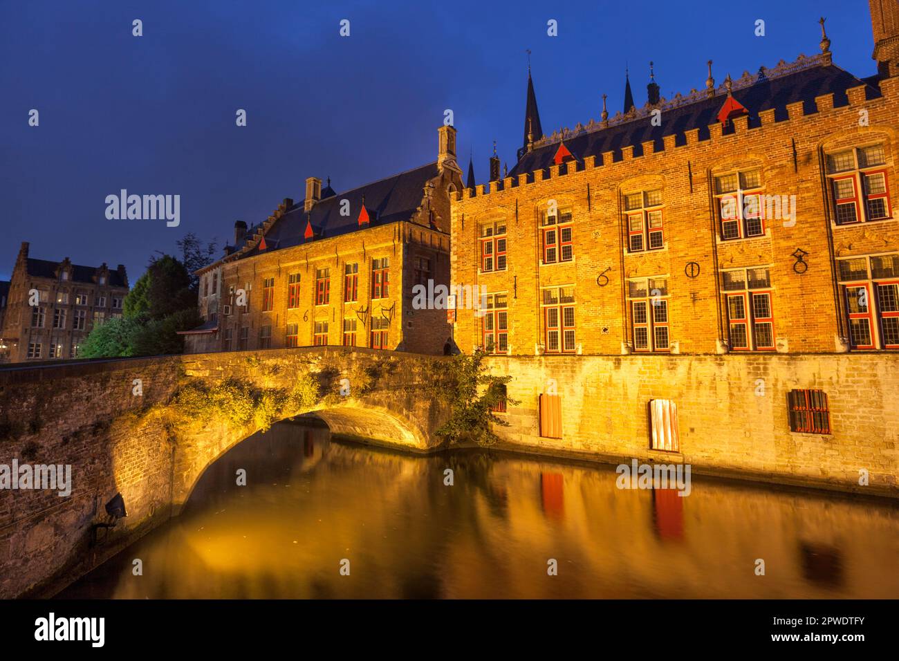 Historische Gebäude an der Brücke Blind Ezelbrug über den Fluss Dijver in Steenhouwersdijk in der Abenddämmerung in Brügge, Belgien, UNESCO-Weltkulturerbe Stockfoto