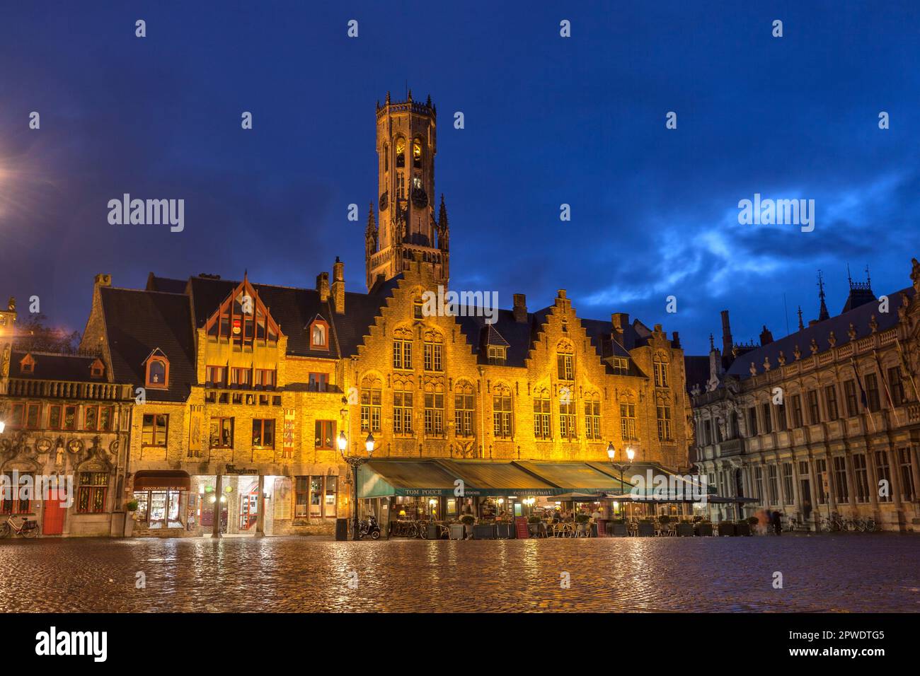 Historische mittelalterliche Gebäude, Cafés und Restaurants am De Burg plaza mit Belfort in der Abenddämmerung in Brügge, Belgien, UNESCO-Weltkulturerbe Stockfoto