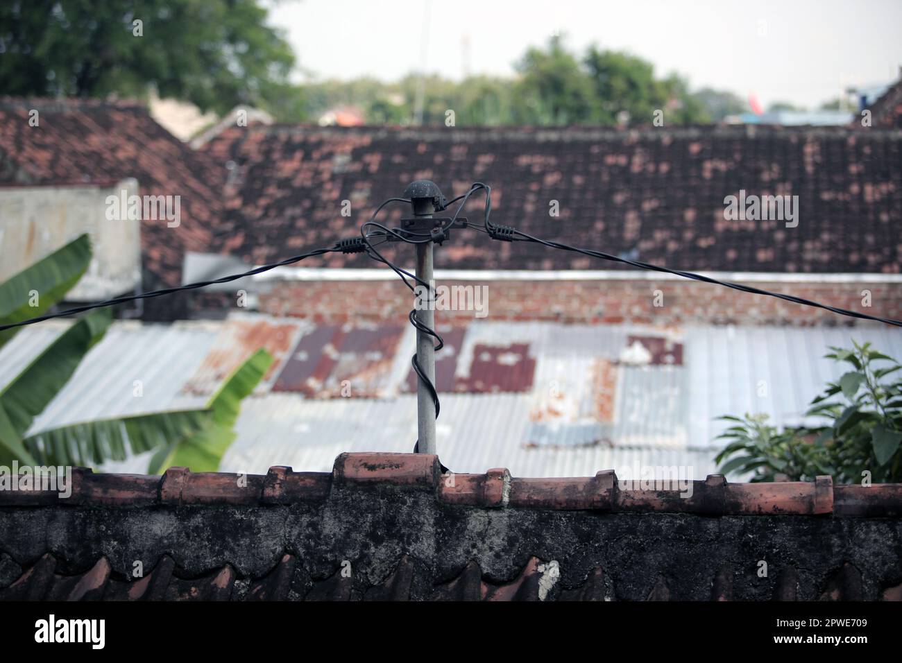 Stromleitungen zu Häusern in indonesischen Dörfern. Gefährliche elektrische Verbindung Stockfoto