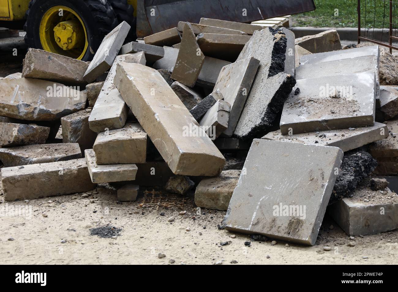 Bauabfälle. Ein Haufen zementgepresster Materialien, Betonschutt, grauer Platten, Bordsteine und Schutt. Reparieren Sie die Straßenverlegung. Industriekonzept Stockfoto