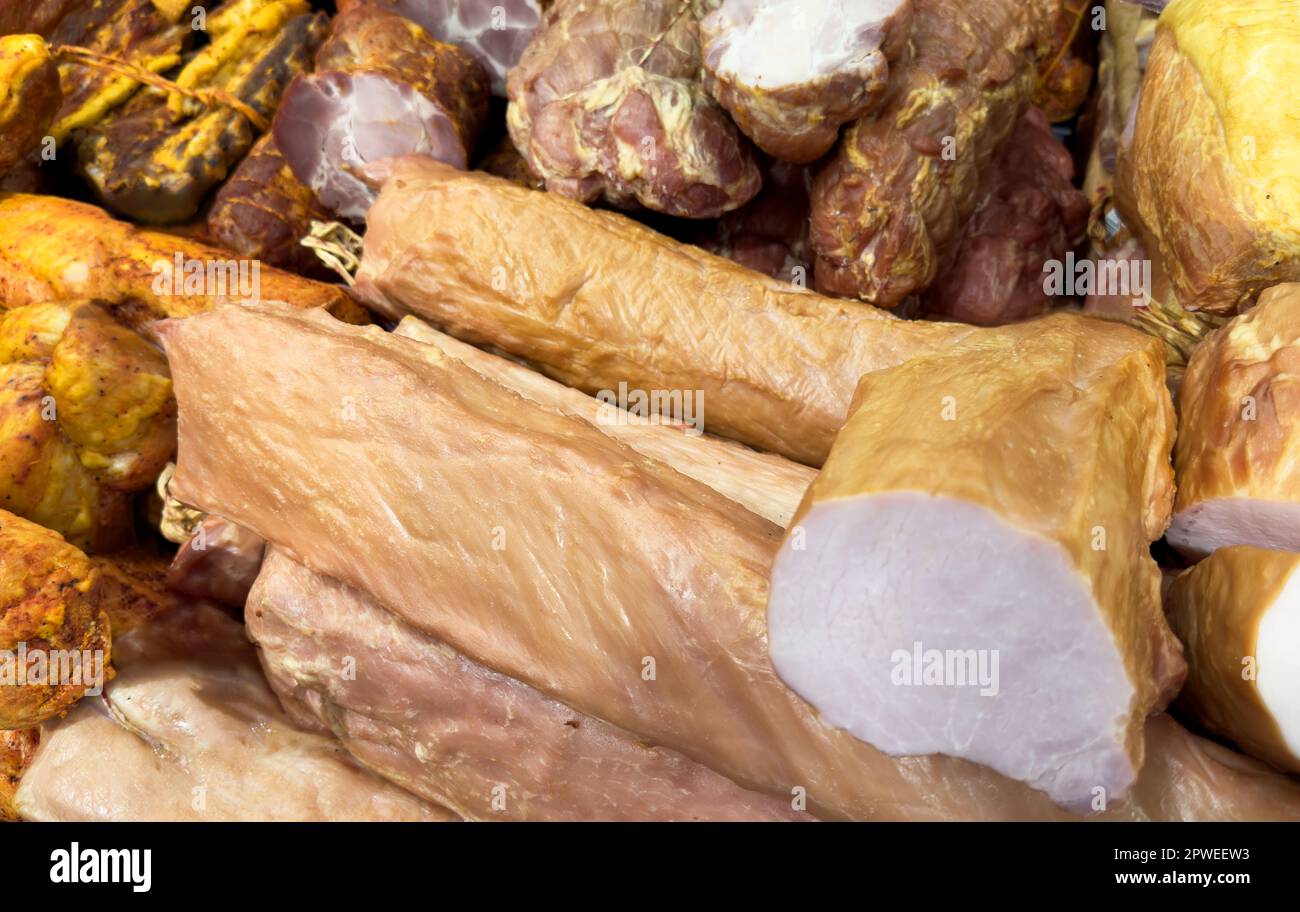 Präsentieren Sie verschiedene Fleischprodukte. Fleisch geräucherte Köstlichkeiten in verschiedenen Farben und Größen. Hausgemachte Fleischspezialitäten Stockfoto