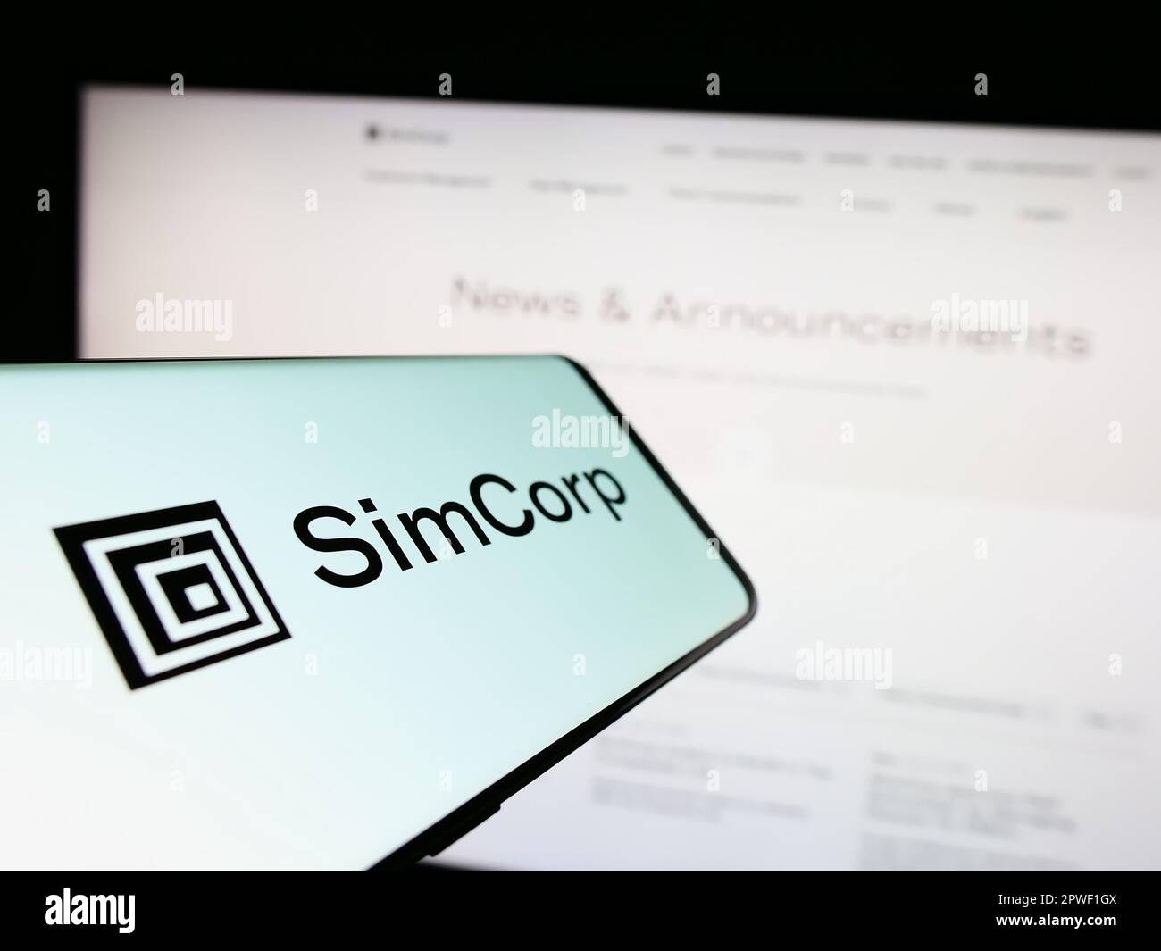 Mobiltelefon mit Logo des dänischen Finanzsoftwareunternehmens SimCorp AUF dem Bildschirm vor der Website des Unternehmens. Konzentrieren Sie sich auf die Mitte des Telefondisplays. Stockfoto