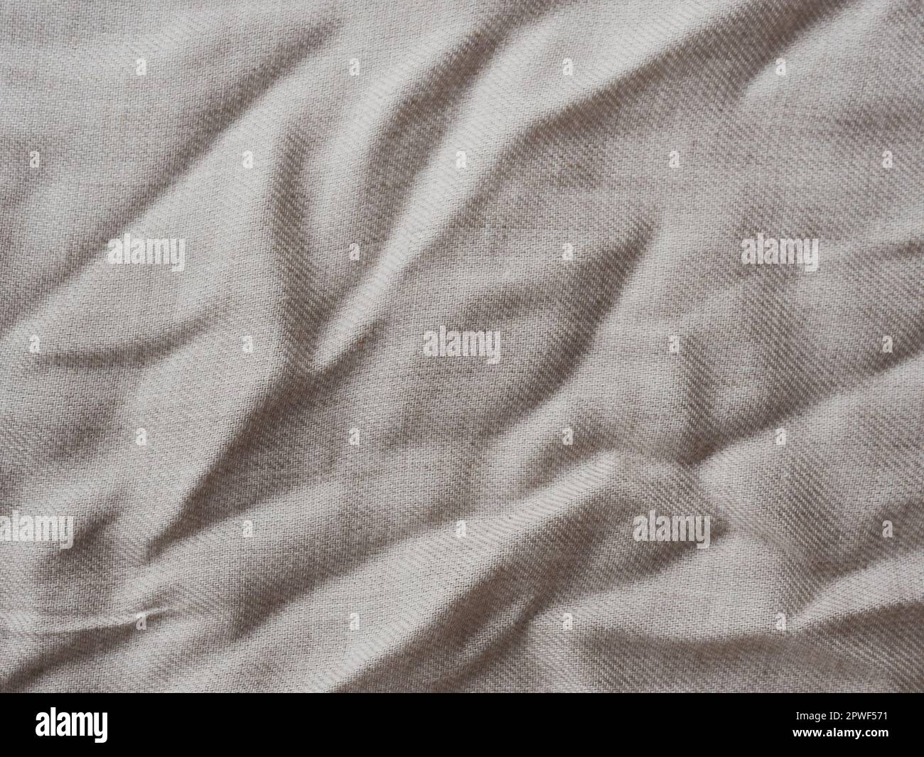 Minimalistischer Hintergrund für Design. Zerknittern Sie beige Leinenstruktur. Detaillierte Nahaufnahme. Rustikaler, zerknitterter Vintage-Baumwollstoff. Bequemes Stylingtuch Stockfoto