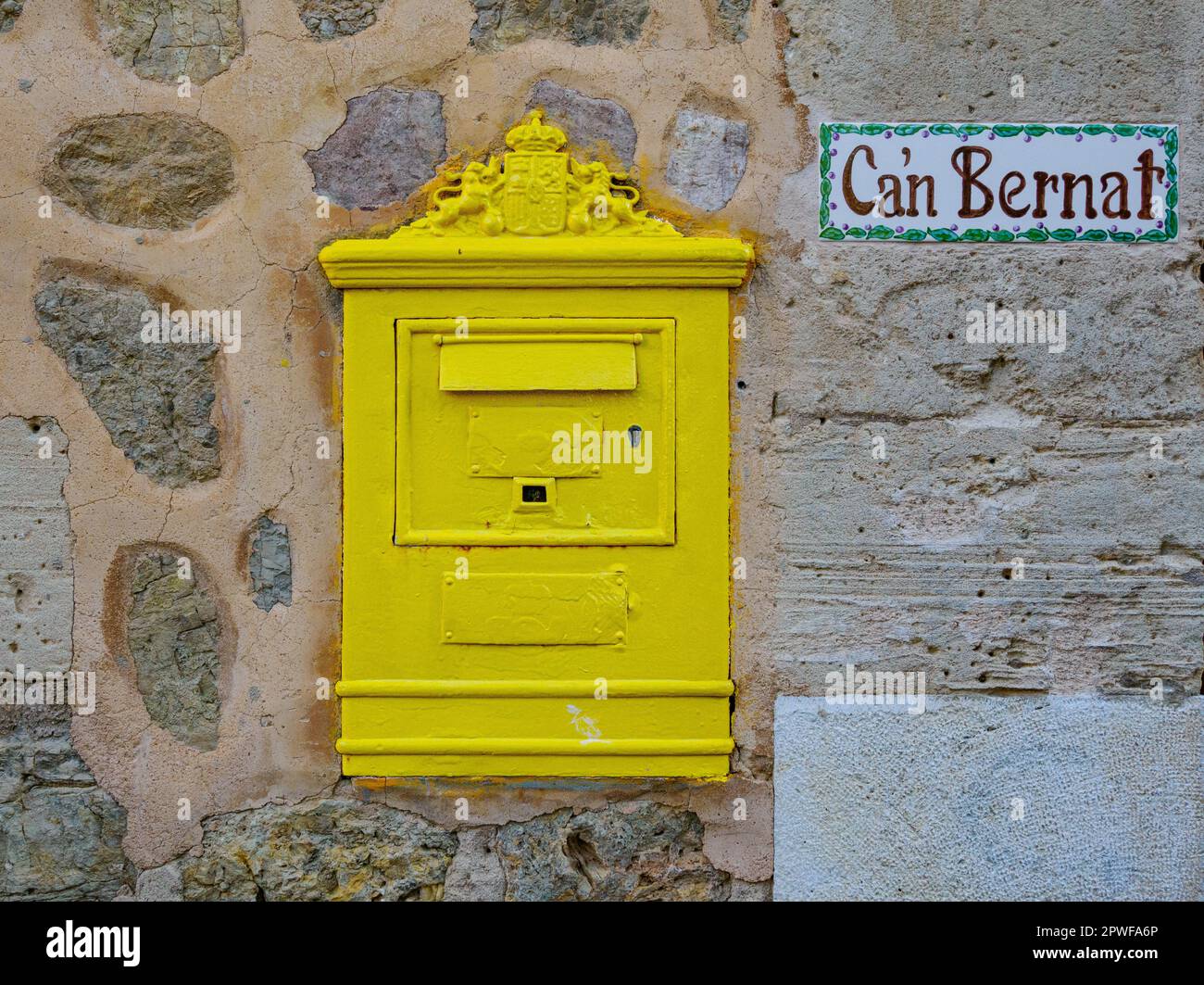 Gelber Briefkasten an einer Wand im Dorf Deia auf Mallorca, Spanien Stockfoto
