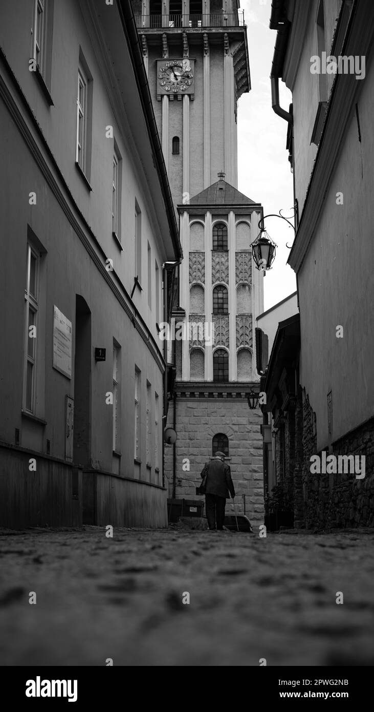 Bielsko Biala St. Nicholas, eine dunkle, einfarbige Stadtgasse mit einem wandelnden alten Mann Stockfoto