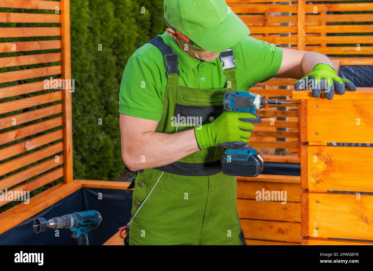 Maßgeschneiderte Holzpflanzen von Caucasian man. Garten Kleine Architekturelemente. Holzmotiv. Stockfoto