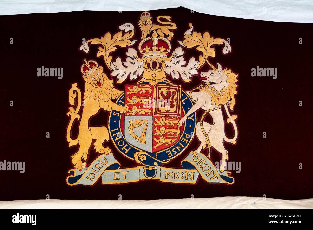 Details des königlichen Wappens auf einem Thronstuhl, wo König Karl III. Und die königliche Gemahlin das Royal College of Needlework im Hampton Court Palace in East Molesey, Surrey, besuchten. Foto: Dienstag, 21. März 2023. Stockfoto