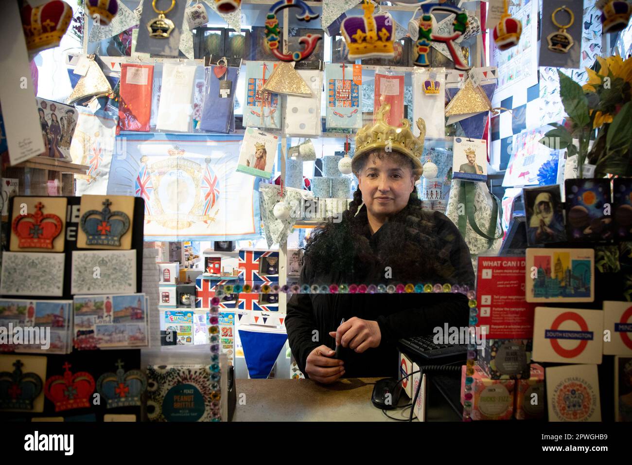 London, Großbritannien. 30. April 2023. Donna in der Medici-Galerie in South Kensington trägt eine aufblasbare Krone. In weniger als einer Woche wird sie zur Krönung von König Karl III. Und Königin Camilla gehen. Sie ist damit beschäftigt, vor dem großen Ereignis, das am 6. Mai 2023 stattfinden wird, Krönungsartikel zu verkaufen. Kredit: Kiki Streitberger/Alamy Live News Stockfoto